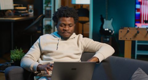 Male remote worker smiling during a virtual meeting with his trainer
