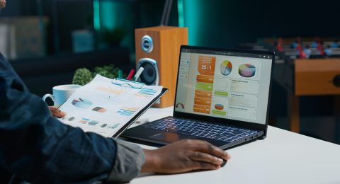 Woman sitting at home office desk, looking at business documents